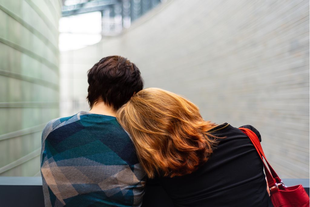 A young woman and woman with their heads on each other's shoulders - Which Rehab