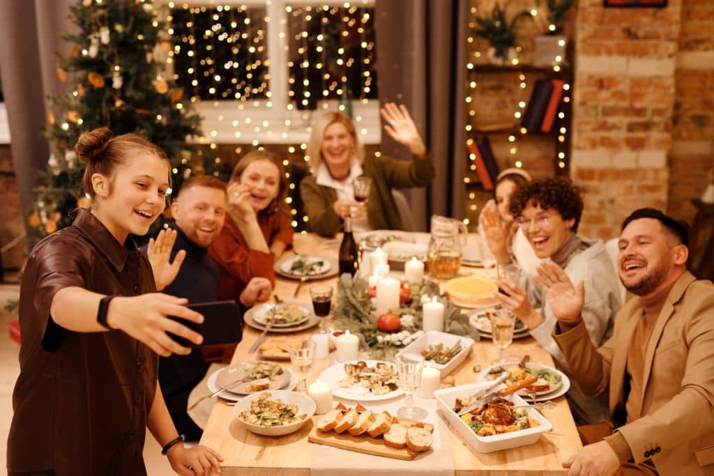 A group of people taking a family selfie and the Christmas dinner table - Which Rehab