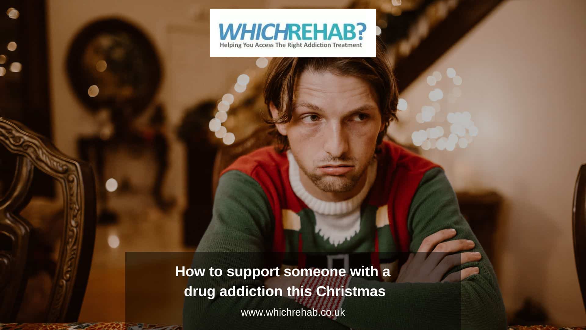 A man sat at a Christmas dinner table wearing a festive jumper looking sullen, with the Which Rehab logo above and the blog title - How to support someone with a drug addiction this Christmas below - Which Rehab