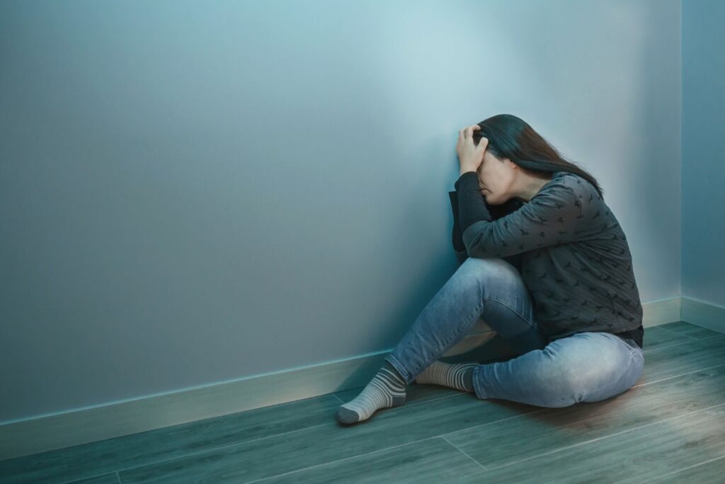 A woman with her head in her hands - Which Rehab
